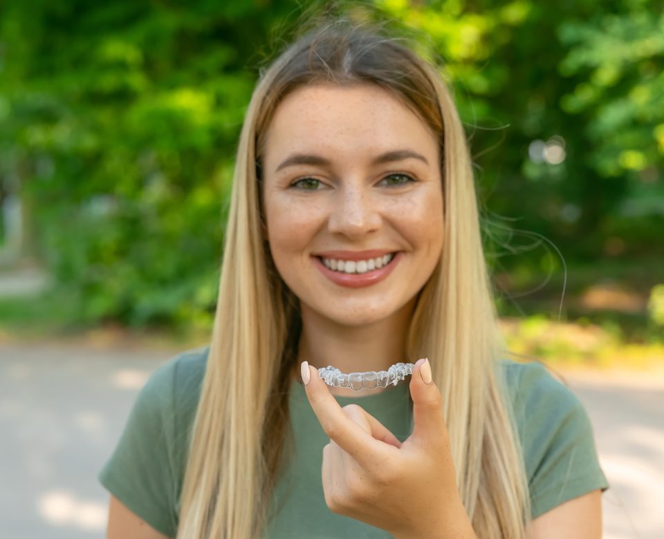 Beautiful Smiling Woman Is Holding An Invisalign Bracer